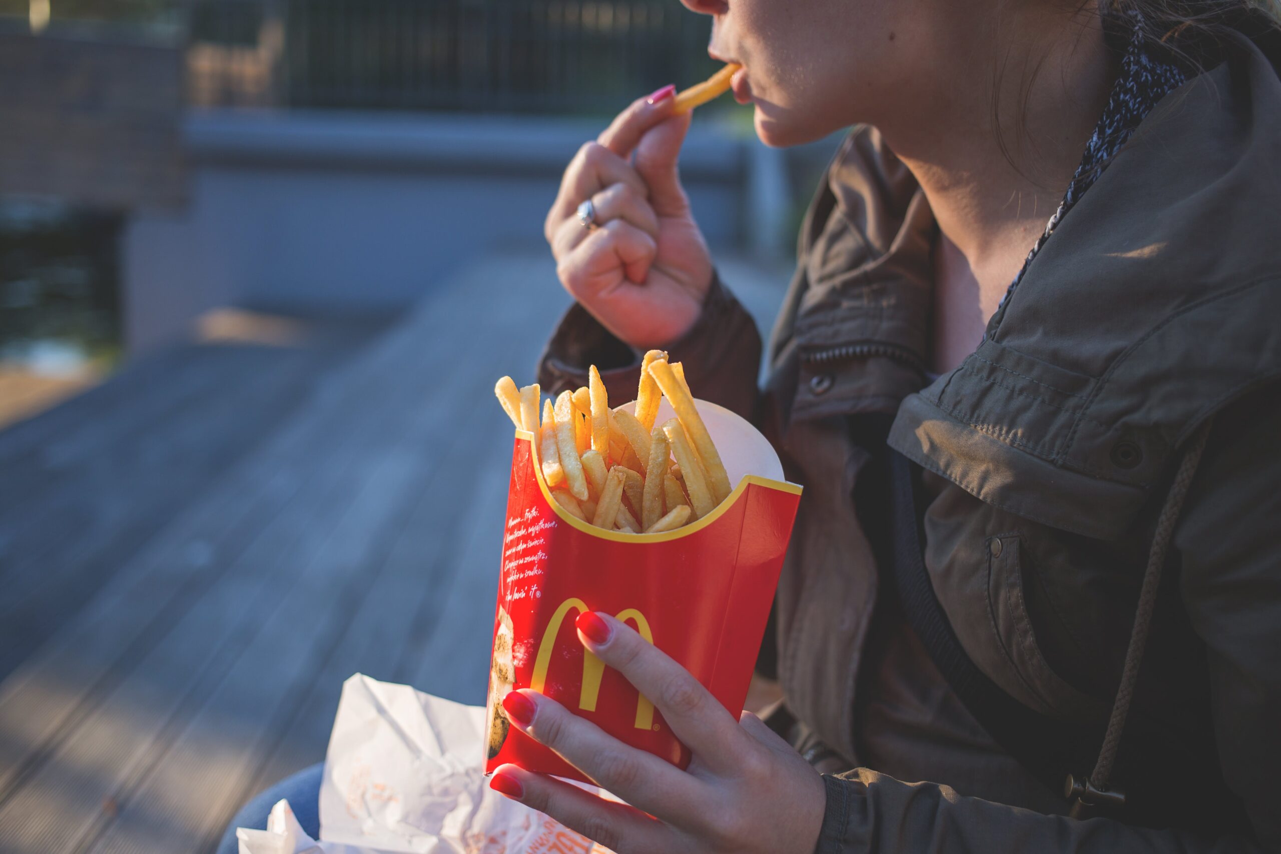 Woman eating fries from McDonalds, one of the most well known examples of colour use in commerical applications.